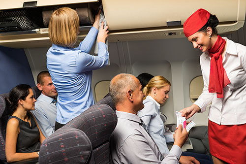 Flight attendant taking care of passengers on a plane